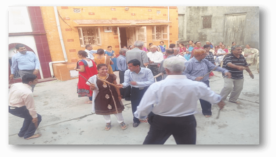 Community members playing Dandiya Raas
