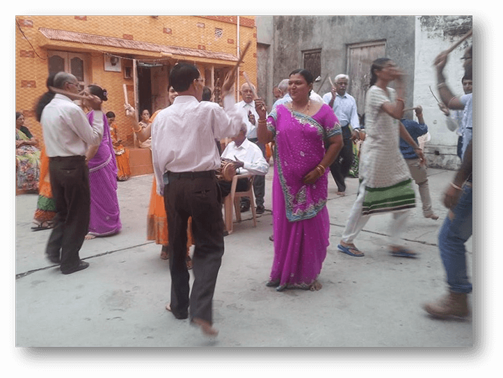 Community members playing Dandiya Raas