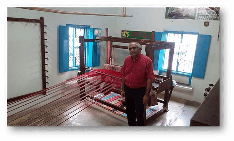 Mr Paresh Amarchande standing beside the weaving machine at the residence of Mr Vijay Kumaldas