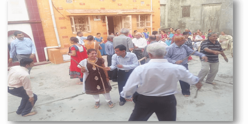 Community members playing Dandiya Raas